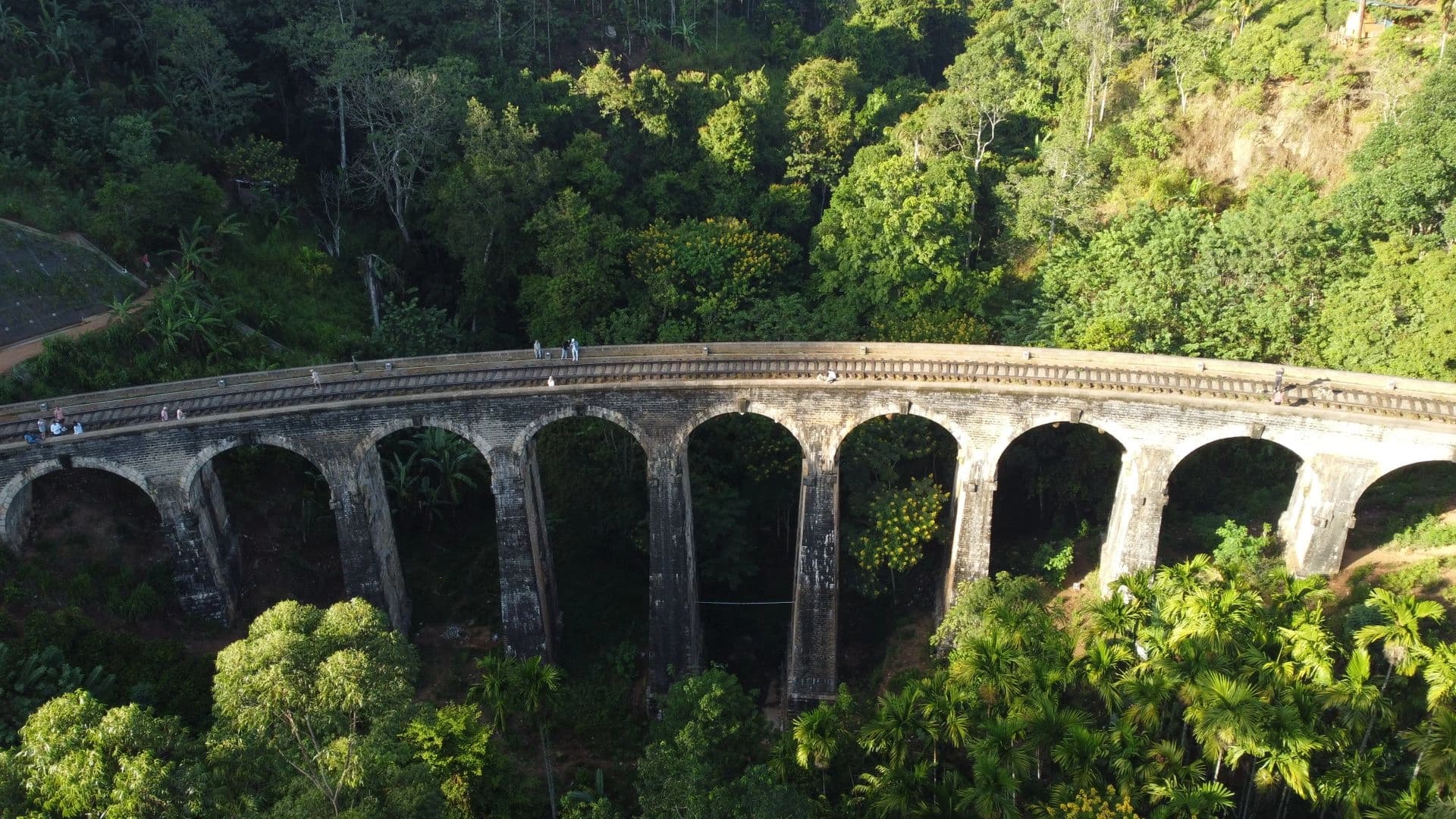 The blue hill-country train crossing Nine Arch Bridge near Ella, Sri Lanka